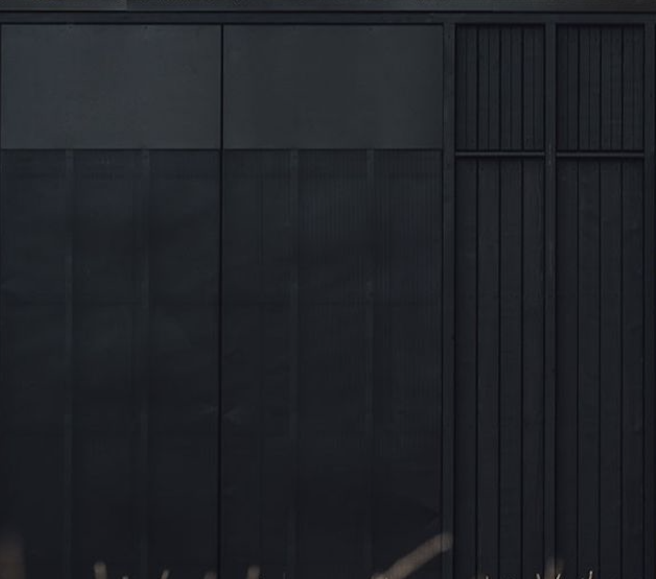 Two women sitting at a modern table talking with a city view behind them.